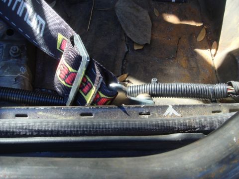 1989 Ford Escort - Close-up view of a seatbelt and wiring harness inside a vehicle.