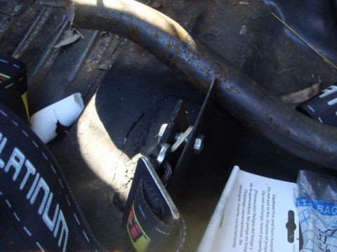 1989 Ford Escort - A close-up view of a safety harness and a metal bar inside a vehicle's interior.