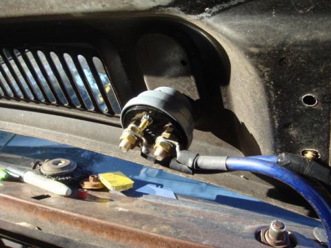 1989 Ford Escort - This photo shows an electrical part, possibly a starter solenoid or relay, mounted on the cowl of a vehicle.