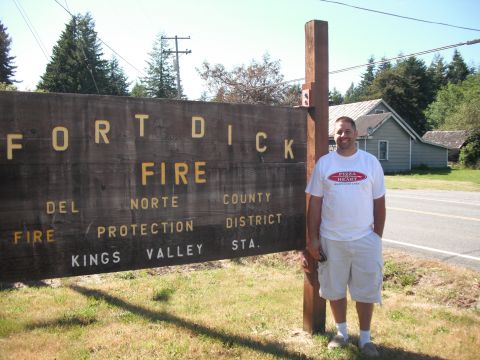 1991 Ford Bronco - A man poses for a photo in front of a weathered wooden sign for the Fort Dick Fire Department.
