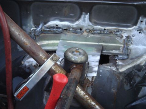 1989 Ford Escort - This image shows a section of a vehicle's frame undergoing repair with welding, various metal components and tools.