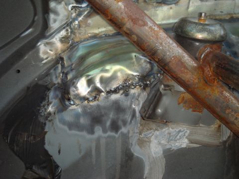 1989 Ford Escort - Welded metal repairs and rusty roll cage tubing are visible in the car's chassis.