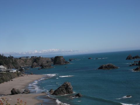 1991 Ford Bronco - Ocean view with rocky coastline and buildings on the cliff edge.