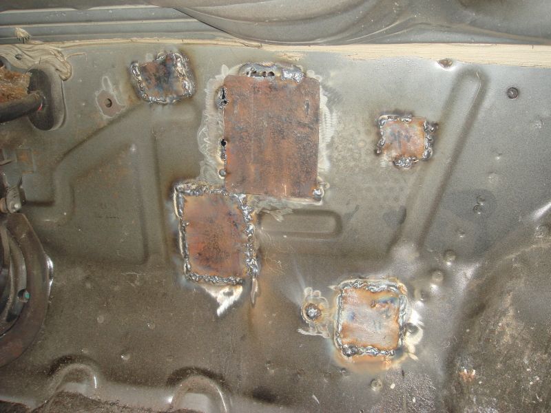 welded patches on a car's floor pan, likely a repair job