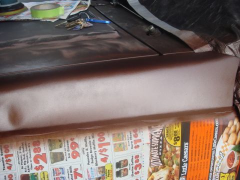 1989 Ford Escort - Car hood and fender covered with masking tape and keys, undergoing repair work.