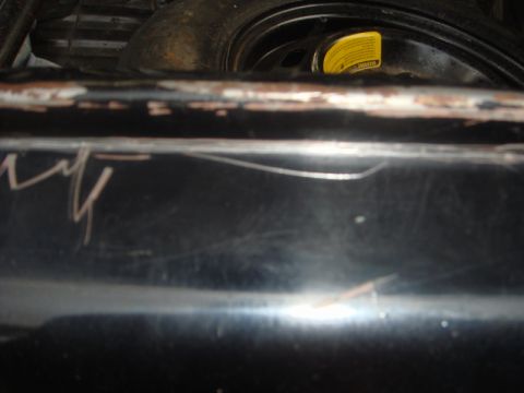 1989 Ford Escort - A close-up view of the trunk interior reveals a spare tire and a yellow warning sticker.