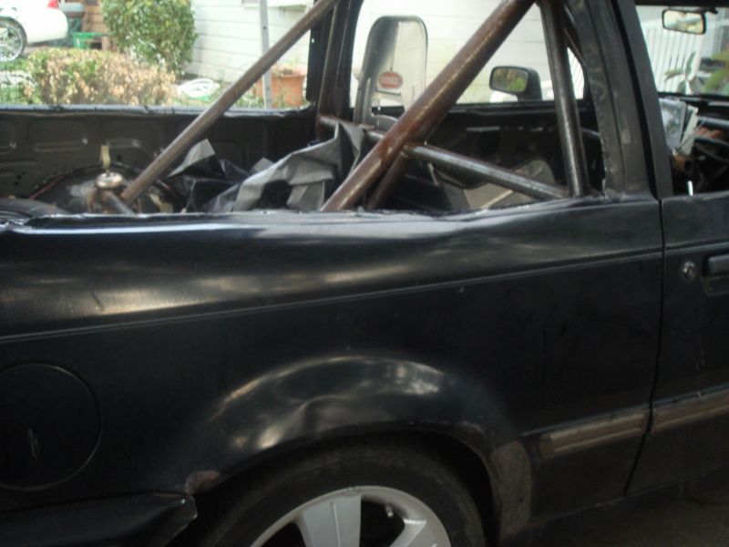 black pickup truck interior with roll cage and tarp covering