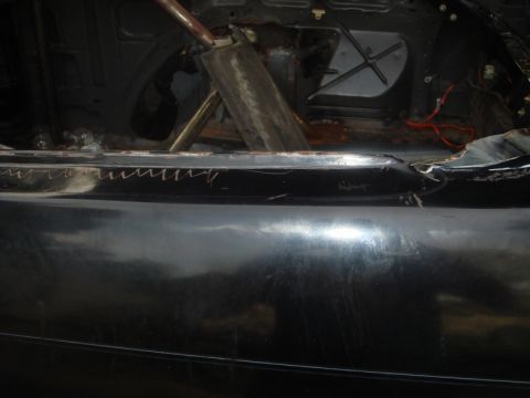 1989 Ford Escort - Interior view of a car undergoing modifications, showing a roll cage and exposed structural elements.