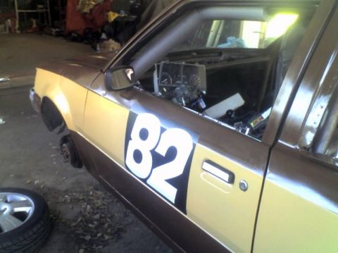 1989 Ford Escort - This race car, marked with the number 82, is shown in a side profile, possibly undergoing preparation or repair.