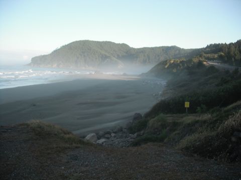 1991 Ford Bronco - A wide view of a misty coastline with a beach and rolling hills.