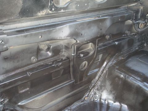 1989 Ford Escort - The interior of a vehicle shows painted metal framing and structural components, with some wiring visible.