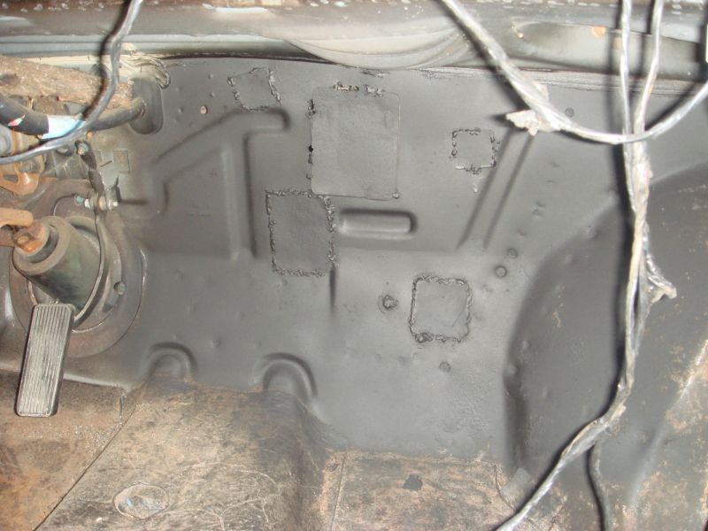 Close-up of a vehicle's firewall showing welded patches and wiring