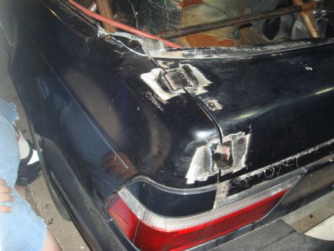 1989 Ford Escort - The rear of a car shows damage and repair work on the trunk lid and body panels.