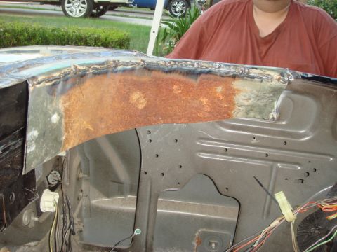 1989 Ford Escort - Repair work on a rusted metal panel, showing welding and new metal patches.
