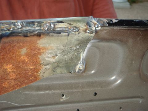 1989 Ford Escort - This image shows a close-up of a metal panel undergoing repair with visible rust and fresh welding work.