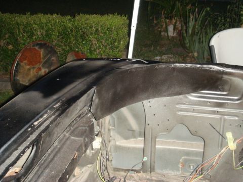 1989 Ford Escort - The interior of a car's fender well shows exposed metal and wiring, suggesting ongoing repairs or modifications.