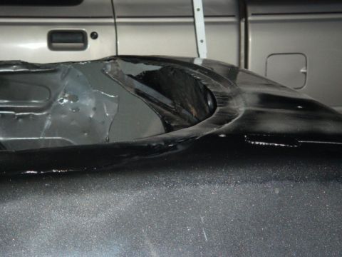 1989 Ford Escort - The image shows the interior of a vehicle's wheel well, with a portion of a truck visible in the background.