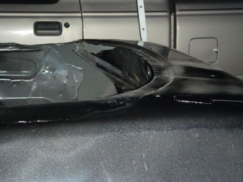 Close-up of car's inner fender well and part of a truck bed