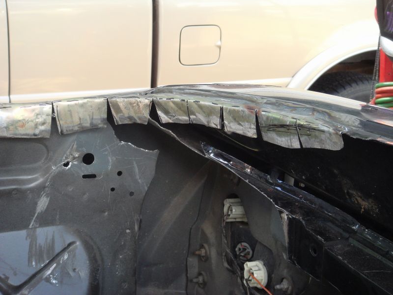 car fender cut and prepped for repair, another vehicle in background