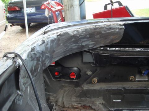 1989 Ford Escort - Close-up of damaged car bodywork, with other vehicles in the background.