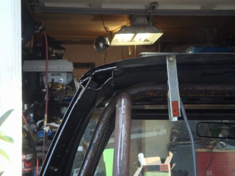 1989 Ford Escort - Close-up of a damaged vehicle roof structure and roll cage in a workshop setting.