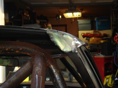 1989 Ford Escort - The image shows a close-up of a car's roof seam undergoing repair work, with a roll cage in the foreground.