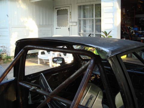 1989 Ford Escort - Custom roll cage installed in a car's interior, with a view of the roof and side mirror.