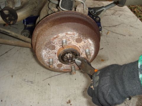 1989 Ford Escort - Close-up of a vehicle's rear brake drum assembly being worked on.