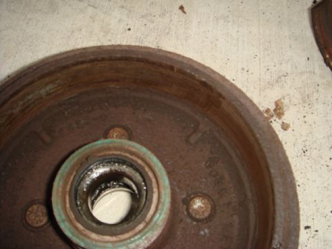 1989 Ford Escort - Close-up of a corroded brake drum, showing wear and a bearing assembly.