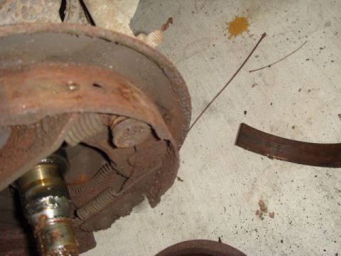 1989 Ford Escort - Close-up of a corroded brake drum and associated parts, likely from an older vehicle.