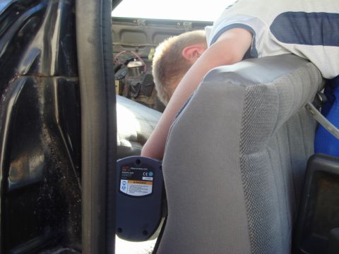 1989 Ford Escort - A person is seen working on the interior of a vehicle, holding a diagnostic tool.
