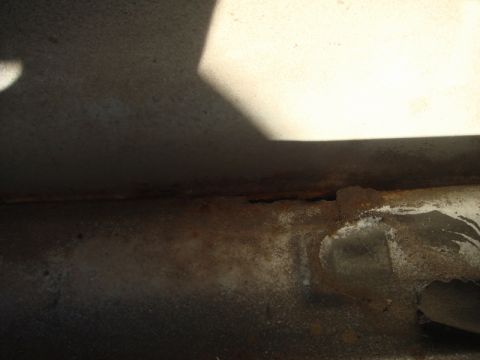 1989 Ford Escort - Close-up view of corroded metal frame, likely part of a vehicle's undercarriage.