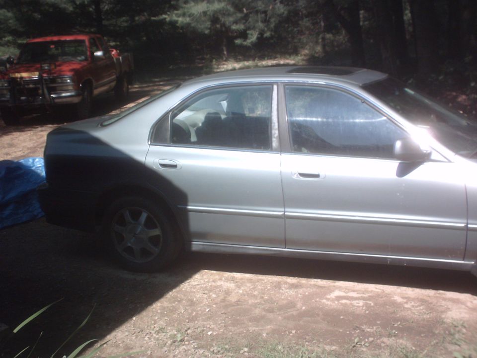 1994 Honda Accord sedan parked next to a red pickup truck