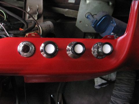 1966 Ford F-100 - Interior view of a red dashboard panel four chrome-trimmed switches with white knobs and readable text.