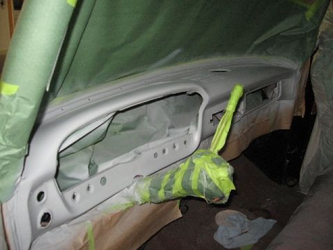 1966 Ford F-100 - The interior dashboard of a vehicle is prepped and masked for a paint job, with the steering column also covered.