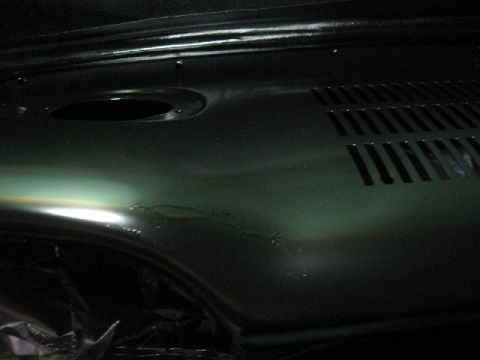 1966 Ford F-100 - Close-up of a painted metal panel with vent slots and a circular opening.