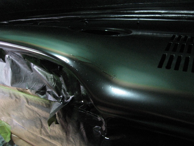 dashboard covered in plastic sheeting, being painted dark green