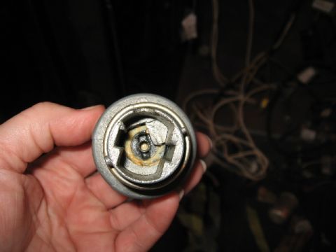 1966 Ford F-100 - A hand holds a worn ignition cylinder lock housing, showing internal damage and wear.
