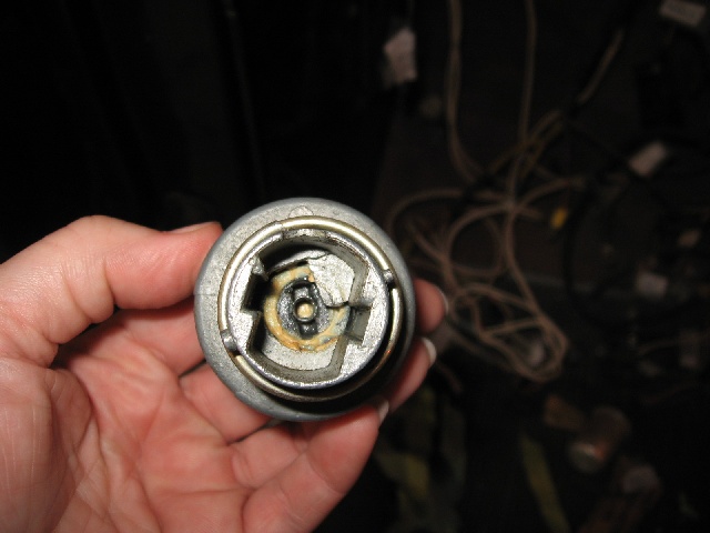 Close-up of a damaged ignition cylinder lock housing held in a hand