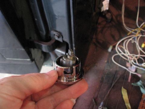 1966 Ford F-100 - Close-up of a vehicle's ignition cylinder being held by a hand, with electrical wires visible in the background.
