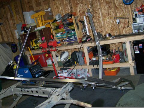 1988 Suzuki Samurai - Workshop scene with metal fabrication parts and welding equipment, Supermotors.net logo present.