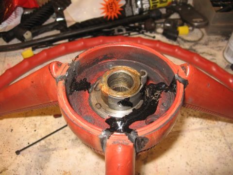1966 Ford F-100 - Close-up of a damaged red steering wheel hub, showing grease and internal components.