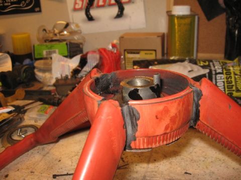 1966 Ford F-100 - Close-up of a steering wheel hub, possibly undergoing restoration or repair, showing internal metal components and orange plastic casing.
