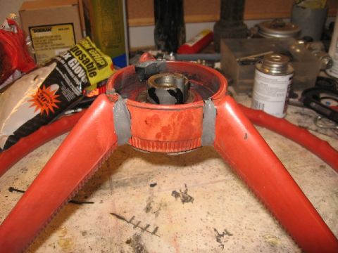 1966 Ford F-100 - A close-up view of a steering wheel hub undergoing repair with epoxy. Various automotive supplies are scattered around the workspace.