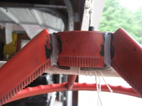 1966 Ford F-100 - A red steering wheel component shows signs of wear and repair, suspended by string.