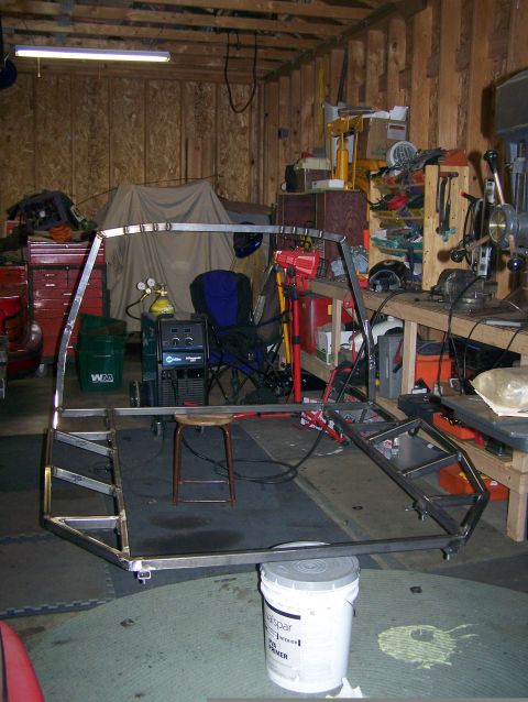 1988 Suzuki Samurai - A bare metal frame sits in a cluttered garage, awaiting further assembly.