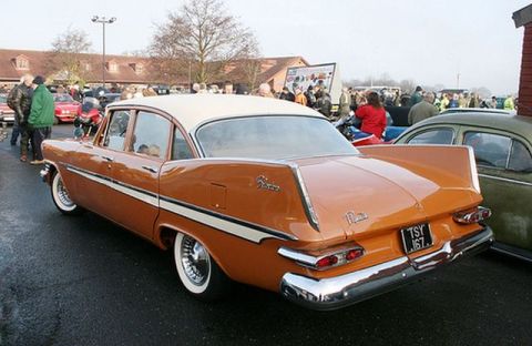 1991 Ford Crown Victoria - A classic Plymouth Belvedere with distinctive tail fins is displayed at a car show with other vehicles and spectators.