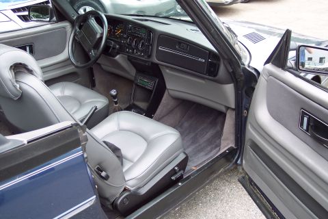 2001 Ford Crown Victoria - The interior of a convertible shows grey leather seats and a dark dashboard.