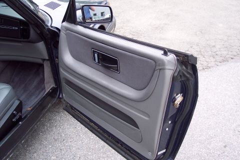 2001 Ford Crown Victoria - Close-up view of the interior door panel and seat of a dark blue vehicle.