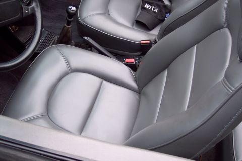 2001 Ford Crown Victoria - Interior view shows leather seats, gear shifter, and a steering wheel; a WRX cap rests on the passenger seat.
